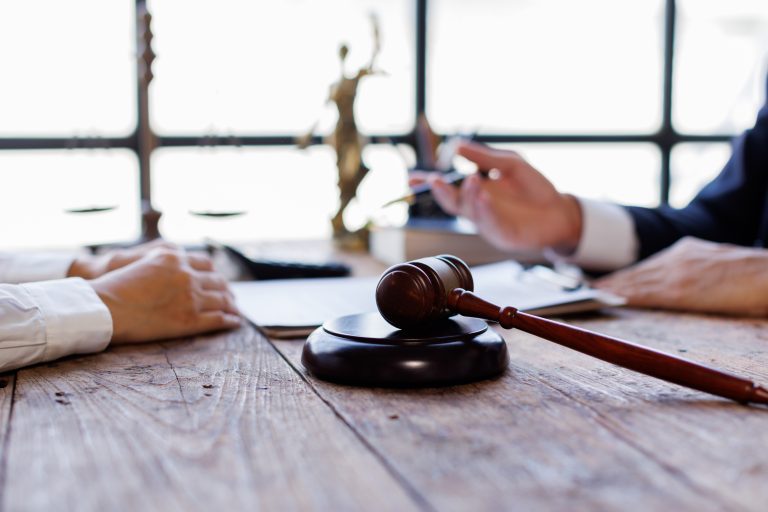 Two lawyers Consultation and conference discussing legal matters at a desk with a gavel, scales of justice law symbolizing law and justice, justice and lawyer Business partnership meeting concept.